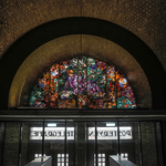 845134 Afbeelding van het halfronde glas-in-lood raam boven de ingang van het voormalig hoofdpostkantoor (Neude 11) te ...